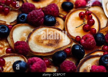 Mini frittelle con frutti di bosco freschi di fondo estate. Foto Stock