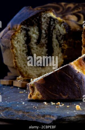 Immagine verticale di un pezzo di delizioso libbra di marmo fatto in casa torta su una tavola di ardesia Foto Stock