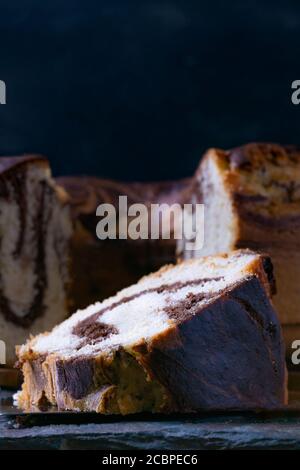 Immagine verticale di un pezzo di delizioso libbra di marmo fatto in casa torta su una tavola di ardesia Foto Stock