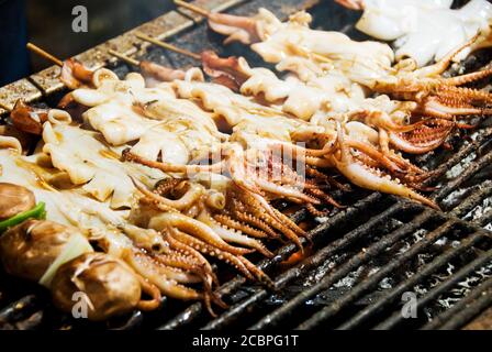 Stack di molti spiedini di calamari alla griglia nel mercato notturno di Taiwan. Foto Stock