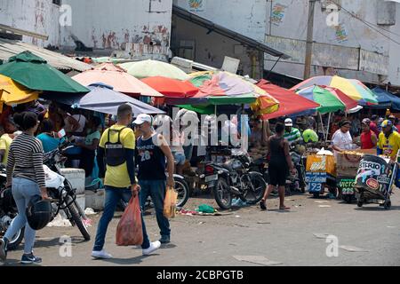 Cartagena Columbia trafficata mercato all'aperto shopping strada. 5092. Storico quartiere povero mercato all'aperto. Carne fresca cruda, carne di manzo, maiale e pesce preparati in condizioni di caldo sanitario. Ambiente sporco e puzzolente con cibo marcio. Ristoranti locali e negozi. Foto Stock