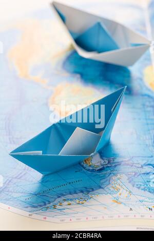 Piccole barche di carta sulla mappa del mondo. Concetto di viaggio o di esercizio militare. Foto Stock