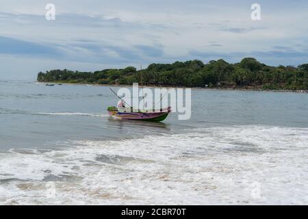 Colorata barca da pesca che brulica su una spiaggia dello sri Lanka, baia di Arugam, Sri lanka Foto Stock