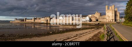 Vista panoramica del castello e delle mura di Caernarfon, costa del Galles del Nord Foto Stock