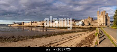 Vista panoramica del castello e delle mura di Caernarfon, costa del Galles del Nord Foto Stock