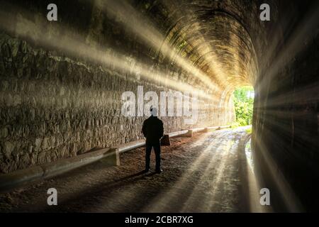 Silhouette viaggiatore uomo esplorato nel tunnel ferroviario antico, abbandonato 19 ° secolo architettura ad oggi vicino a da Lat, Vietnam Foto Stock