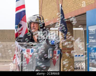 Sheerness, Kent, Regno Unito. 15 agosto 2020. L'elettricista pensionato Tim Bell di Minster on Sea, di 75 anni, Kent trasformò il suo scooter da mobilità in un carro armato con accatastamento, bolle ed effetti di fumo per commemorare il 75° anniversario del VJ Day. Ha iniziato la giornata raccogliendo al di fuori di Tesco per carità (i soldi raccolti andrà a lungo termine carità Kent Air Ambulance). Credit: James Bell/Alamy Live News Foto Stock