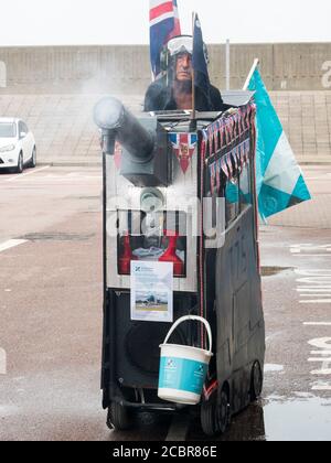 Sheerness, Kent, Regno Unito. 15 agosto 2020. L'elettricista pensionato Tim Bell di Minster on Sea, di 75 anni, Kent trasformò il suo scooter da mobilità in un carro armato con accatastamento, bolle ed effetti di fumo per commemorare il 75° anniversario del VJ Day. Ha iniziato la giornata raccogliendo al di fuori di Tesco per carità (i soldi raccolti andrà a lungo termine carità Kent Air Ambulance). Credit: James Bell/Alamy Live News Foto Stock