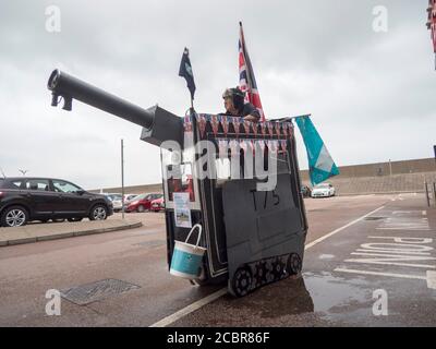 Sheerness, Kent, Regno Unito. 15 agosto 2020. L'elettricista pensionato Tim Bell di Minster on Sea, di 75 anni, Kent trasformò il suo scooter da mobilità in un carro armato con accatastamento, bolle ed effetti di fumo per commemorare il 75° anniversario del VJ Day. Ha iniziato la giornata raccogliendo al di fuori di Tesco per carità (i soldi raccolti andrà a lungo termine carità Kent Air Ambulance). Credit: James Bell/Alamy Live News Foto Stock