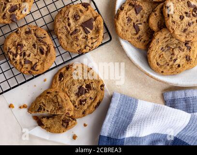 Sopra i biscotti di scheggiatura di cioccolato su un piatto e raffreddamento rack Foto Stock