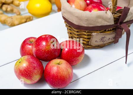 belle mele rosse mature appetitose in un cesto. quattro mele sul tavolo Foto Stock