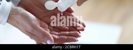 Donna che applica antisettico per pulire le mani Foto Stock