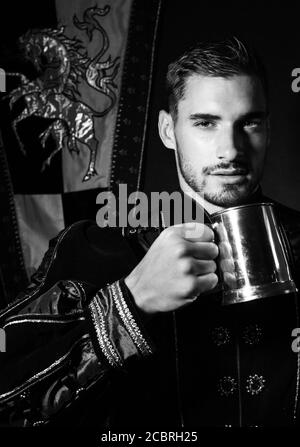 Ritratto di re attraente con barba vestita in costume con tankard guardando la macchina fotografica Foto Stock