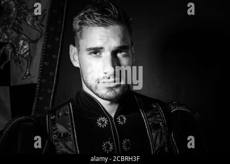 Ritratto di re attraente con barba vestita in costume alla telecamera Foto Stock