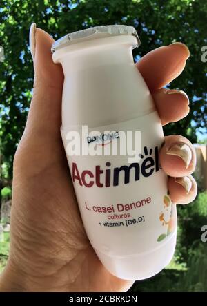 Yogurt Actimel in mano sullo sfondo di alberi Foto Stock