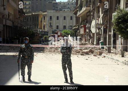 Cairo, Egitto. 15 agosto 2020. Il personale addetto alla sicurezza si trova a guardia nei pressi del sito dove un edificio è parzialmente crollato nel centro di Cairo, Egitto, il 15 agosto 2020. Quattro persone sono state ferite quando un vecchio edificio nella via Qasr al-Nilo del Cairo è parzialmente crollato il sabato, secondo i rapporti. Credit: Ahmed Gomaa/Xinhua/Alamy Live News Foto Stock