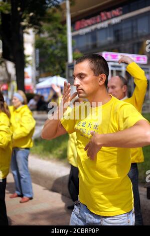 Seguaci del movimento religioso Falun dafa che fa ginnastica respiratoria Chi Kung in strada. 1° giugno 2012. Kiev, Ucraina Foto Stock