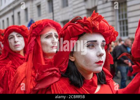 Londra, Regno Unito - 18 ottobre 2019: Una fila di estinti ribellione Red Brigade manifestanti sfilare a Londra