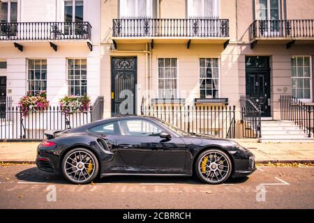 Londra- Porsche parcheggiata fuori case a schiera a Knightsbridge Foto Stock