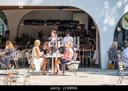 Londra - Agosto 2020: Cameriera che serve i clienti in un ristorante all'aperto sul Duke of York Square su Kings Road, Chelsea Foto Stock