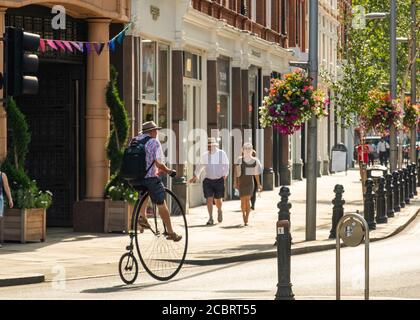 Londra - Agosto 2020: Un uomo su una penny farthing bike sulla Kings Road, Chelsea Foto Stock