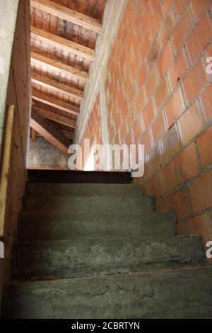 Lavori di costruzione in una casa incompleta in mattoni rossi e cemento con dettagli in stile architettonico in campagna Foto Stock