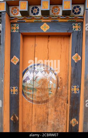 Bhutan, Gangtey, Gangtey Village. Dettaglio architettonico, ornato legno dipinto con motivo a gru a collo nero per cui la valle è famosa. Foto Stock