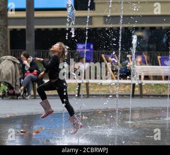 Londra, Regno Unito. 15 agosto 2020. Un bambino gioca nelle fontane di Leicester Square. Credit: Liam Asman/Alamy Live News Foto Stock