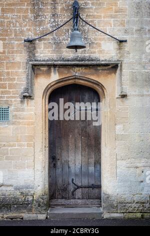 Vecchia porta di legno a casa nel villaggio medievale di Lacock, Wiltshire, Inghilterra, Regno Unito Foto Stock