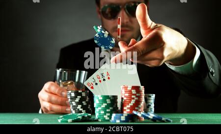 Giocatore di poker gettando chip. Concetto di gioco di rischio, chip di poker sul tavolo Foto Stock