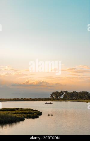 Assam, india - 12 agosto 2020 : Boatman con un bel paesaggio all'ora d'oro. Foto Stock