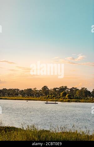 Assam, india - 12 agosto 2020 : Boatman con un bel paesaggio all'ora d'oro. Foto Stock