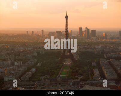 Di strade e di edifici di appartamenti sotto la Torre Eiffel a Parigi al tramonto con edifici a La Defense in skyline Foto Stock