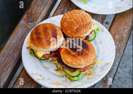 hamburger fatto in casa con cipolla bianca e pomodoro. Produzione di hamburger fatti in casa. Fast food Foto Stock