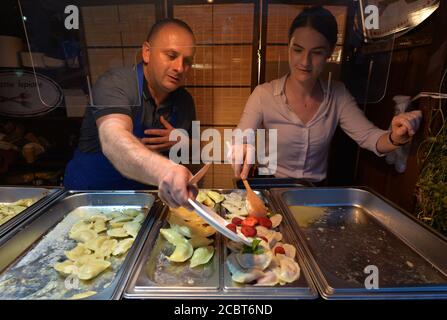 Cracovia, Polonia. 14 agosto 2020. Assistenti di vendita che aggiungono i gnocchi durante il festival annuale 'Pierogi' (gnocchi) alla Piazza del piccolo mercato di Cracovia. Durante il festival vengono preparate una varietà di gnocchi. Credit: Cezary Kowalski/SOPA Images/ZUMA Wire/Alamy Live News Foto Stock