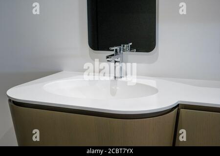 Lavabo in ceramica con piano bianco e miscelatore in metallo lucido. Foto di alta qualità Foto Stock