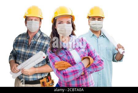 Appaltatori femminili e maschili in cappelli duri che indossano maschere mediche per il viso durante il Coronavirus Pandemic isolato su bianco. Foto Stock