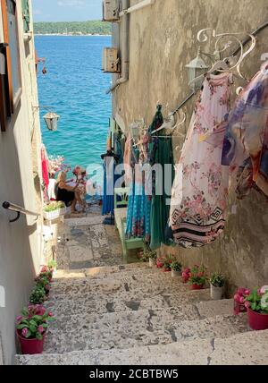 Donna in una stretta strada di pietra vicino al mare Adriatico. Rovigno, Istria / Croazia. Foto Stock