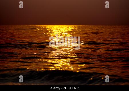 Tramonto sul mare. Spettacolare luce rossa fuoco sopra le onde di sfondo. Foto Stock