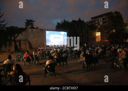 Bucarest, Romania. 15 agosto 2020. I residenti con maschere guardano un film in un cinema all'aperto a Bucarest, Romania, 15 agosto 2020. Il governo rumeno mantiene la chiusura di cinema e teatri in mezzo alla pandemia COVID-19, ma permette film all'aperto o spettacoli con un pubblico limitato e norme di prevenzione delle epidemie. Credit: Gabriel Petrescu/Xinhua/Alamy Live News Foto Stock