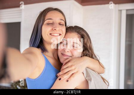 Due Sorelle si abbracciano con Amore Foto Stock