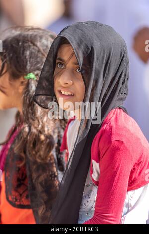 Omani ragazza che partecipa alle aste di bestiame del venerdì al souq di Nizwa Foto Stock