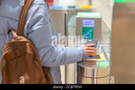 Carta d'imbarco elettronica e controllo dei passaporti in aeroporto - mano con carta d'imbarco sullo smartphone al tornello. Foto Stock