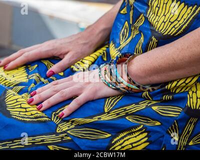 Mani ben curate di una donna bianca sullo sfondo di Un costume africano tradizionale chiamato 'boubou' Foto Stock
