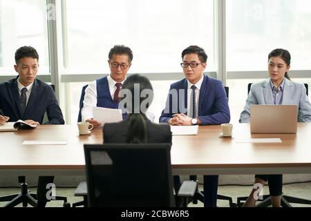 giovane cercatore di lavoro asiatico intervistato da un gruppo di dirigenti aziendali Foto Stock
