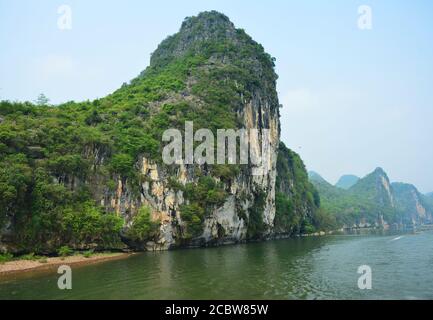 Montagna verde che si erge accanto al fiume li a Guilin della Cina Foto Stock