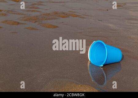 Secchio di plastica di un bambino abbandonato su una spiaggia Foto Stock