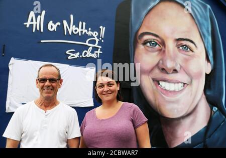 Megan Nicell, sorella di Suor Clare Crockett, e Danny Doyle, padrino e zio della suora tarda, di fronte ad un nuovo murale di Suor Crockett, davanti ad un servizio di benedizione per il murale di Domenica sera. Il murale di Suor Crockett, che fu ucciso in un terremoto in Ecuador nel 2016, fu dipinto dalla compagnia UV Arts vicino alla sua casa a Brandywell, Derry. Foto Stock