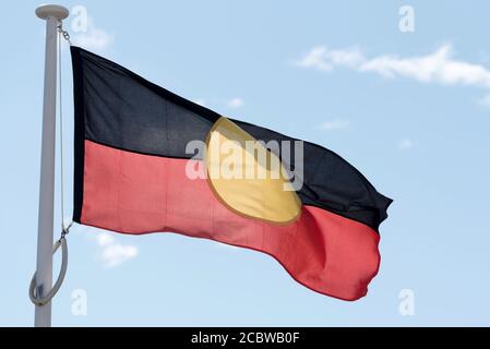 La bandiera aborigena australiana è la bandiera ufficialmente designata e regolamentata degli aborigeni australiani (prime Nazioni). Foto Stock
