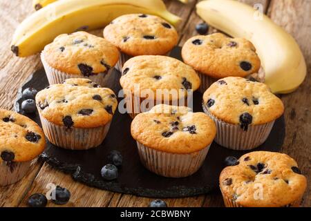 Muffin appena sfornati con mirtilli e banane da vicino su una tavola di ardesia sul tavolo. Orizzontale Foto Stock